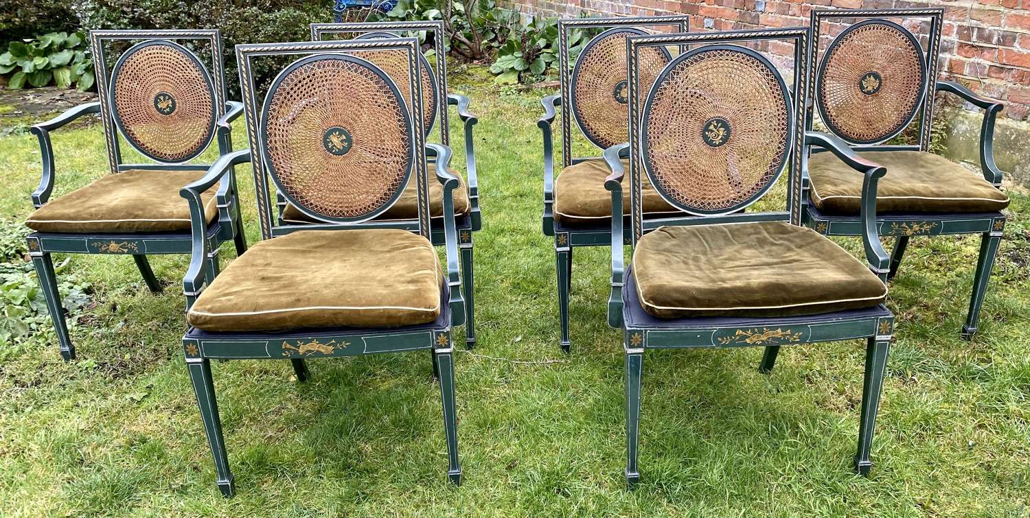Six painted and caned dining chairs